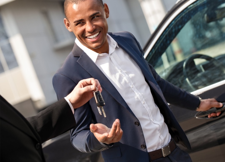 Agent Giving Keys To Young Man Standing Near Car Smiling Playful Purchase