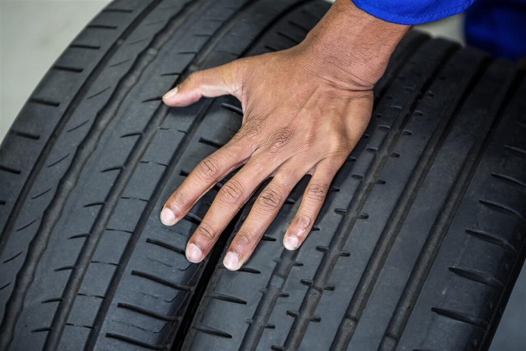 Hand Mechanic Holding Tyres