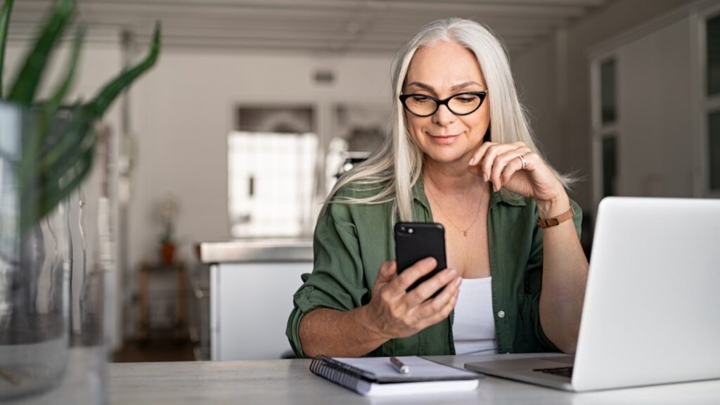 Woman Using Mobile Phone And Lap